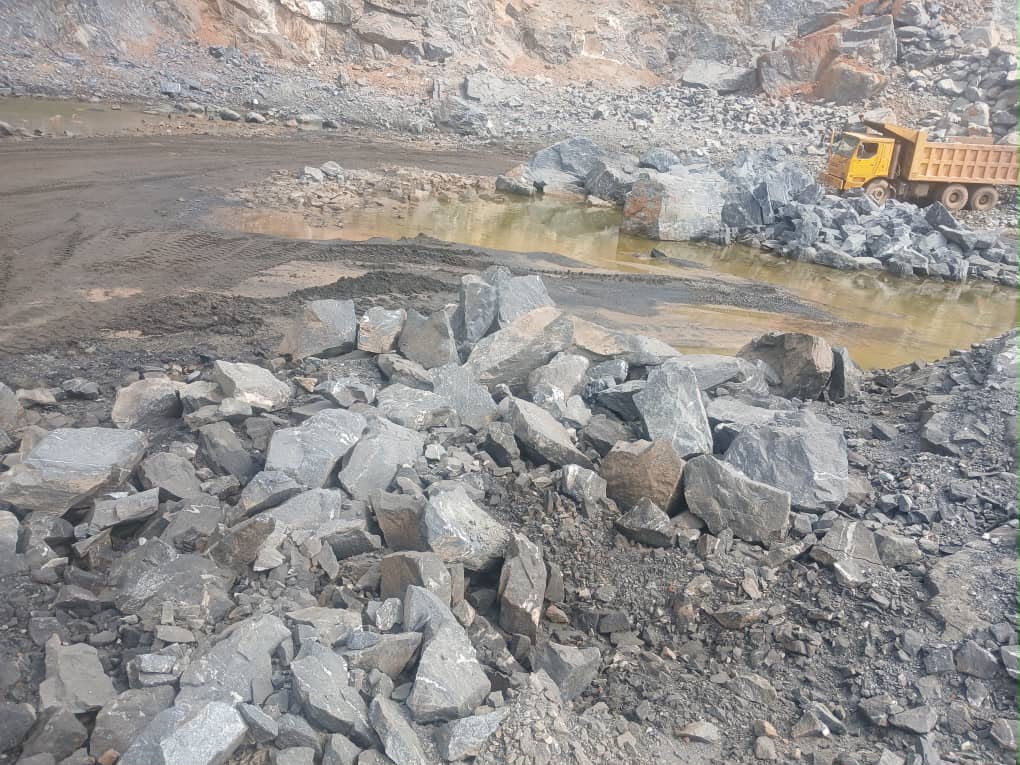 Active quarry operation with blasted rock and haul truck